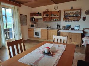 a kitchen with a wooden table and a table and chairs at Haus Galler - Urlaub am Bauernhof in Bad Aussee