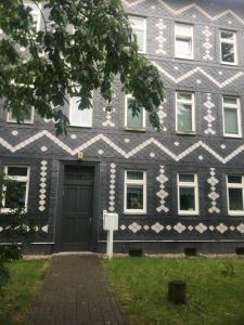 a black building with a black door and white stripes at Apartment Ferienwohnung Blumenstadt in Erfurt