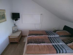 a bedroom with two beds and a white wall at Schanzenblick in Winterberg +1 photo