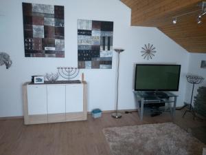 a living room with a flat screen tv on a wall at Schanzenblick in Winterberg