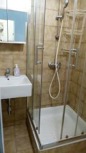 a shower with a glass door next to a sink at RoooMS by JR City Apartments in Vienna