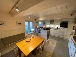 a kitchen with a wooden table and a dining room at Koopmanns-Hus in Immenstedt