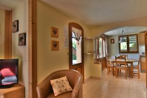 a living room with a television and a dining room at CHALET SERRE CHEVALIER AVEC VUE EXCEPTIONNELLE in Puy-Saint-Pierre