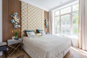 a bedroom with a large bed and a large window at Jogailos Residence peaceful Old Town luxury 3 bdr, 2 bthr, FREE GARAGE, top-speed WIFI in Vilnius