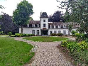 un camino empedrado frente a una casa blanca en Domein Hengelhoef, en Aan de Wolfsberg