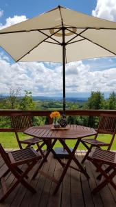 een picknicktafel met een paraplu op een terras bij Nature house with amazing view in Petrinja