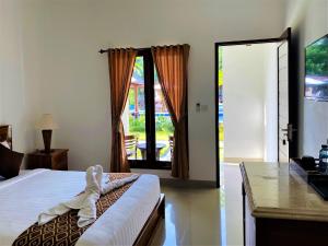 - une chambre avec un lit et une porte donnant sur une terrasse dans l'établissement Uluwatu Jungle Villa, à Uluwatu