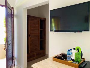 a room with a flat screen tv on a wall at Uluwatu Jungle Villa in Uluwatu