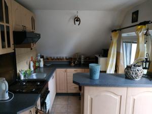 uma cozinha com armários brancos e um balcão azul em Ubytování na Šumavě em Sušice