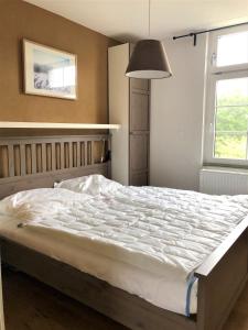 - une chambre avec un grand lit blanc et une fenêtre dans l'établissement Haus Meerliebe, Whg 2, à Cuxhaven
