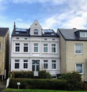 une maison blanche avec une tour en haut dans l'établissement Haus Meerliebe, Whg 2, à Cuxhaven