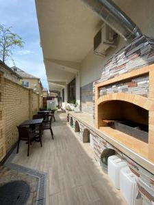 a patio with a brick wall and tables and chairs at Sadko on Shevchenko in Anapa