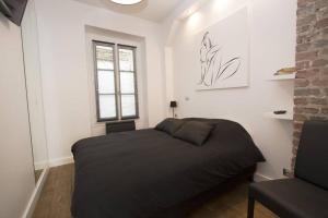 a bedroom with a bed in a room with a window at The Designer Apartment in Paris
