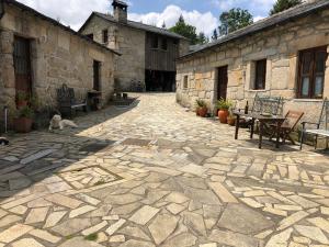 einen steinernen Innenhof mit Stühlen und Tischen in einem Gebäude in der Unterkunft Quinta das Uchas in São Pedro do Sul