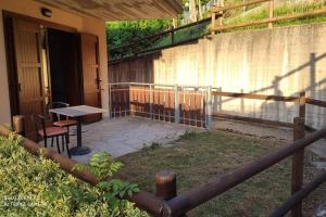 d'une terrasse avec une table, des chaises et une clôture. dans l'établissement Locazione Turistica Sestola con giardino, à Sestola