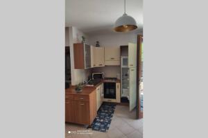 a kitchen with wooden cabinets and a counter top at Locazione Turistica Sestola con giardino in Sestola