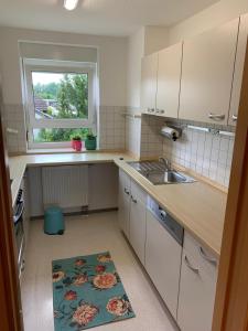 a small kitchen with a sink and a window at Anytime - Ferienwohnung Rita in Friedrichshafen in Friedrichshafen