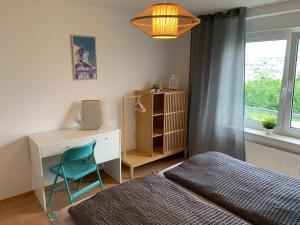 a bedroom with a desk and a bed and a chair at Anytime - Ferienwohnung Rita in Friedrichshafen in Friedrichshafen