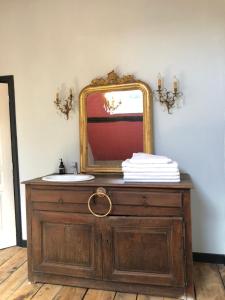 a bathroom with a sink and a mirror on a dresser at Manoir de la Foulquetiere in Luçay-le-Mâle