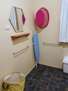 a bathroom with a mirror and a blue umbrella at Golden Mt Rest on James in Mount Morgan +10 photos