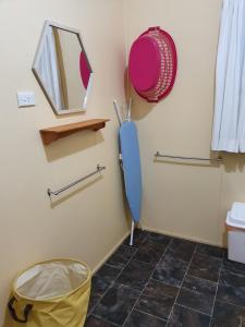 a bathroom with a mirror and a blue umbrella at Golden Mt Rest on James in Mount Morgan