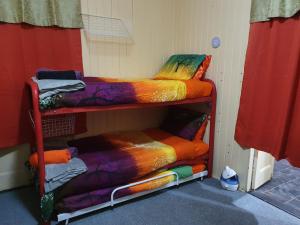 a room with two bunk beds with colorful blankets at Golden Mt Rest on James in Mount Morgan
