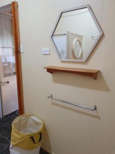 a mirror on a wall with a trash can at Golden Mt Rest on James in Mount Morgan