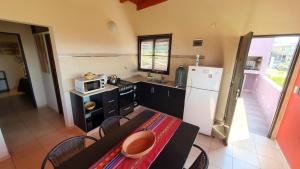 
a kitchen with a table and chairs and a refrigerator at Alta Morada in Villa Carlos Paz
