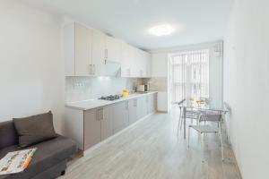 a kitchen and a living room with a couch and a table at DomkoLviv in Lviv