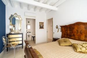 um quarto com uma cama grande e uma cadeira em La Musa em Veneza