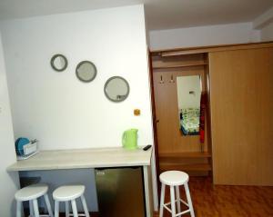 a kitchen with a counter and stools next to a door at Dom na Wzgórzu in Jastarnia