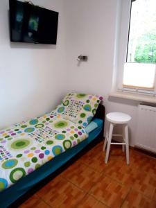 ヤスタルニャにあるDom na Wzgórzuの小さなベッドルーム(ベッド1台、スツール付)