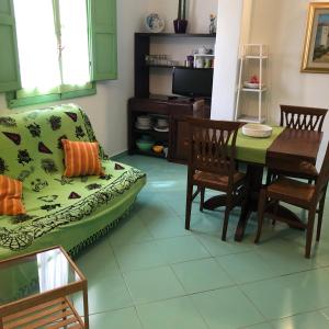 ein Wohnzimmer mit einem Sofa und einem Tisch in der Unterkunft Castelletto Verde in Bari Sardo