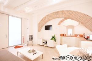 a white living room with a white couch and a table at Le Nuove Cadreghe Apartments in Verona