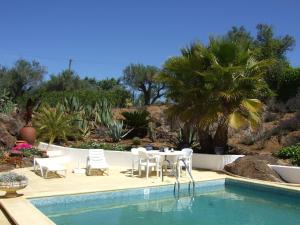 a patio with a table and chairs next to a pool at Quinta Do Cano in Évora