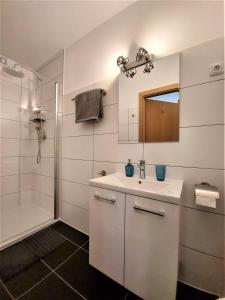 a white bathroom with a sink and a shower at Haus Christl am Horn in Sankt Johann in Tirol