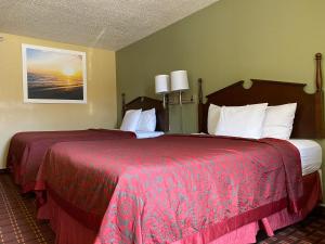 a hotel room with two beds with red sheets at Days Inn by Wyndham Morton in Morton