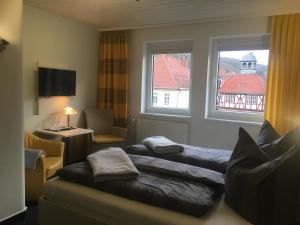 a hotel room with two beds and a window at Café Feldmann & Pension in Bad Sooden-Allendorf