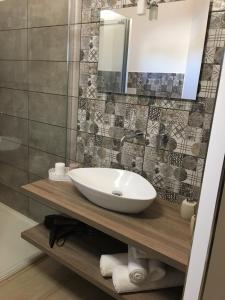een badkamer met een wastafel en een spiegel bij La casetta di viale Paradiso in Pachino