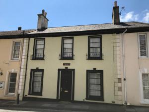 a yellow building with black windows and a door at Scarborough House - Adults only holiday home in Torquay