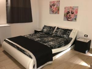 een slaapkamer met een bed in een kamer met schilderijen bij La casetta di viale Paradiso in Pachino