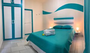 una camera da letto con letto verde e cuscini blu di Abiki Mauritius ad Albion