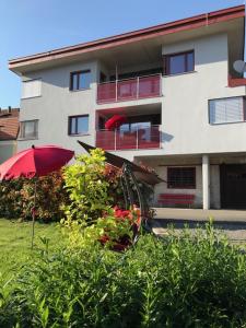 a building with a red umbrella and a plant at Posthof Apart . Zimmer in Zirl