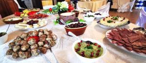 a table topped with lots of different types of food at Pensiunea Tabacaru in Peştera