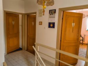 a hallway with two wooden doors and a staircase at Harmónia Vendégház in Németbánya