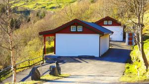 a red and white garage with a white door at Hole Hytter in Geiranger