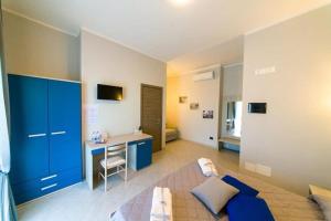 a large room with a bed and a desk in it at AFFITTACAMERE BORGATA MARINA in Roseto Capo Spulico