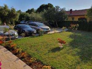 a group of cars parked in a yard with flowers at VILLA NIKOLINA in Medulin