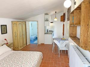ein Schlafzimmer mit einem Bett und einem Tisch sowie eine Küche in der Unterkunft S.M. IL CASTRO in Monteriggioni