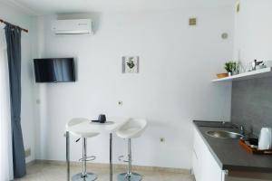 a kitchen with two white stools and a sink at Apartments Vanda in Rovinj +2 photos